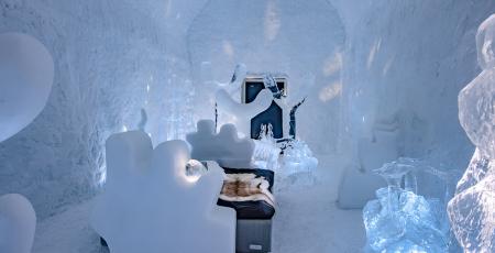 bedroom filled with figurative ice art inside Icehotel