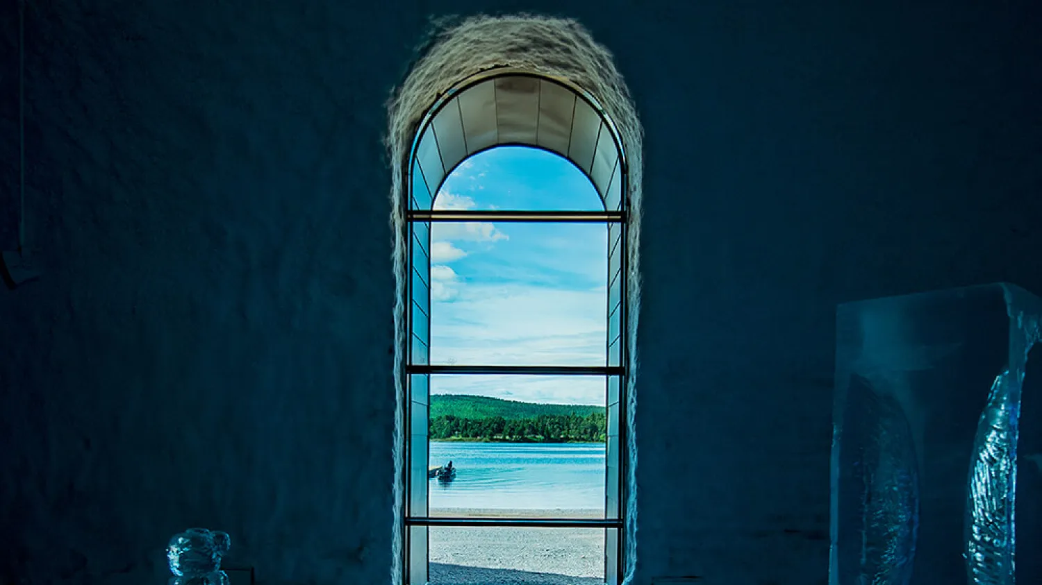 Photo taken from the inside of Icehotel 365 you can see summer outside the window