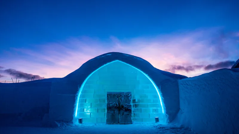 The iconic entrance to Icehotel 29 in blue and purple light