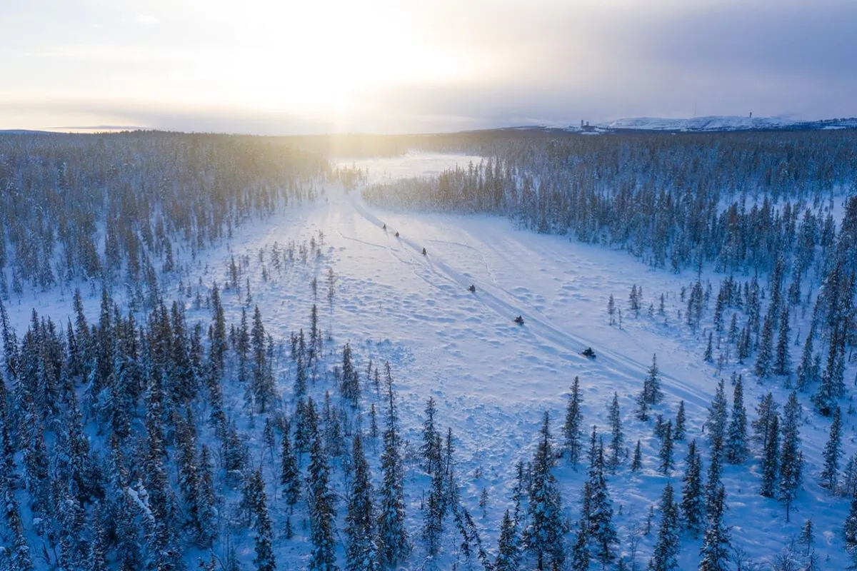 drone shot of snowmobiles in the wilderness