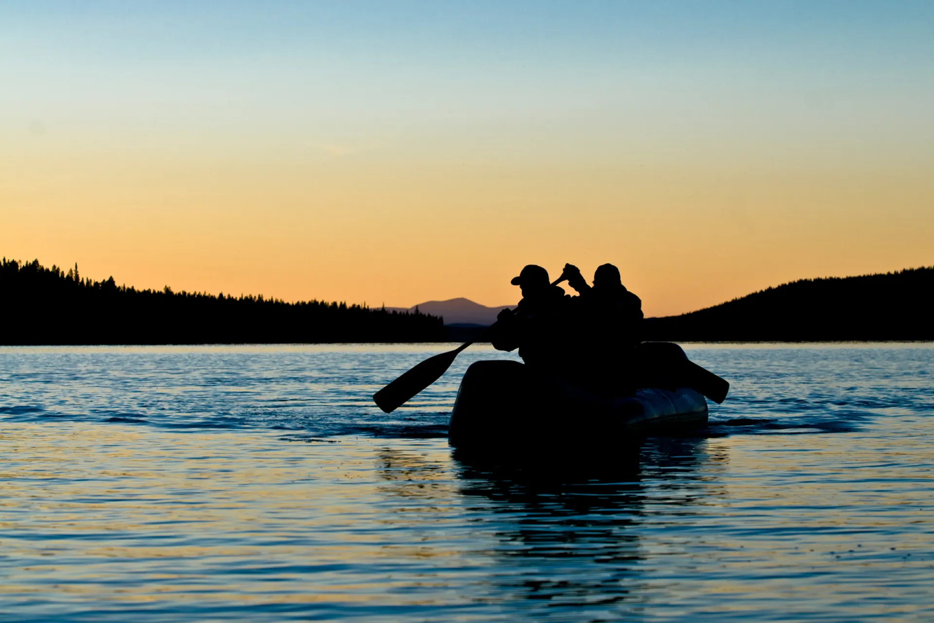 two people canoing during sunset