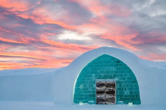 entrance to icehotel with pink sky above