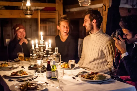 group of people having dinner in a cabin